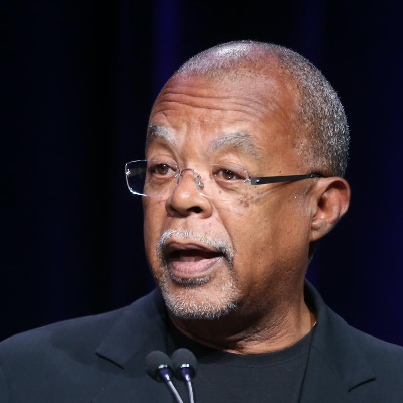 Professor Henry Louis Gates Jr. speaks on stage against a black backdrop