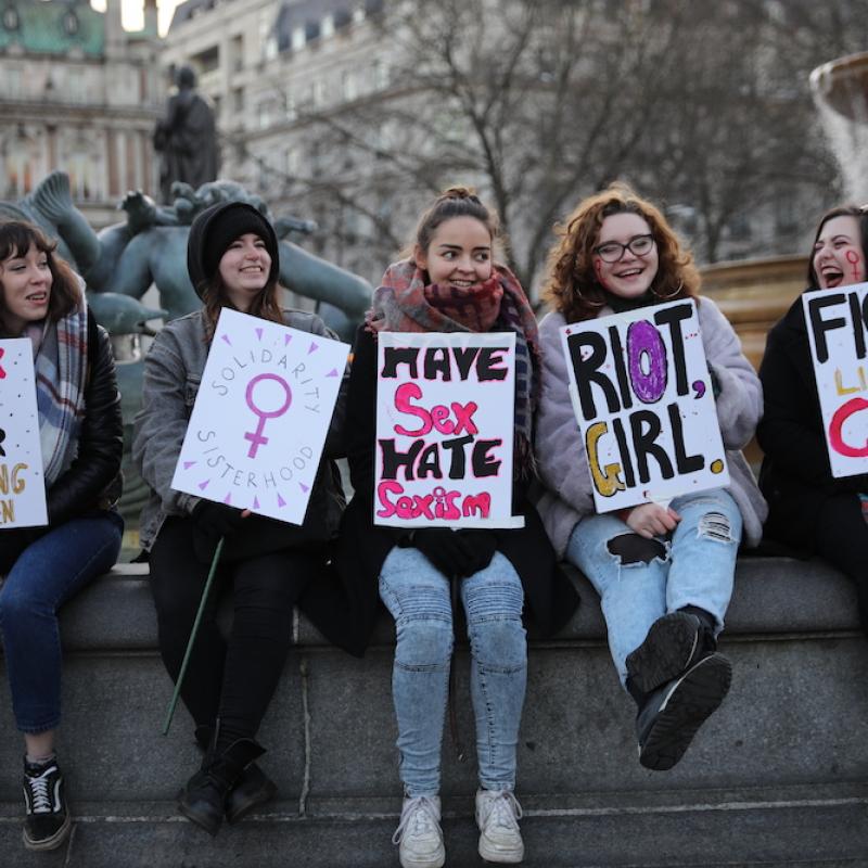 Young girls holding feminist signs at a protest