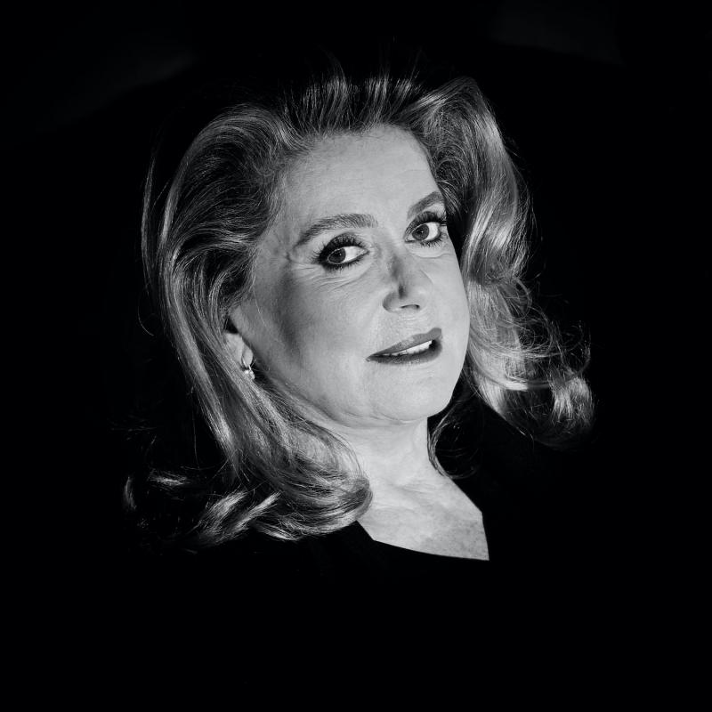 Actress Catherine Deneuve against a black backdrop